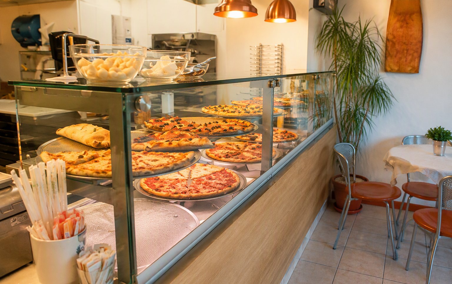 La zona d'asporto con la vetrina refrigerata e le tavole della sala